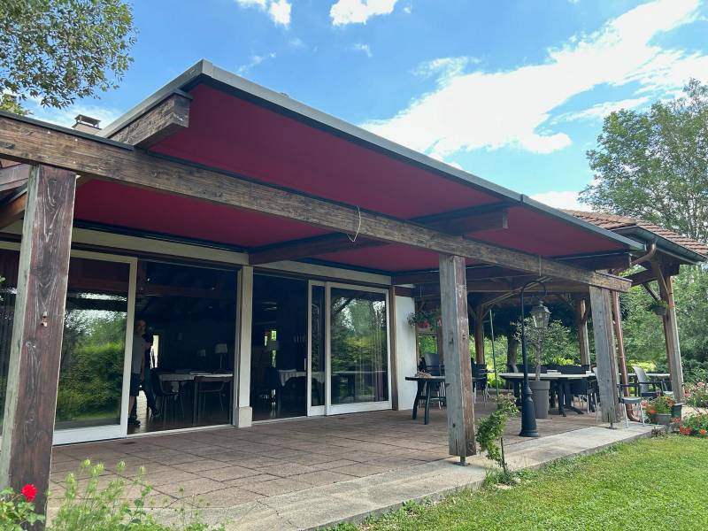 Remplacement d’un store de toiture zippé rouge à côté de Nantua pour la terrasse d’un restaurant